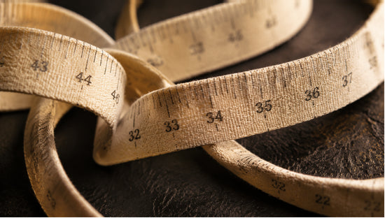 Close-up abstract photograph of a coiled measuring tape with warm lighting, representing berberine's potential role in supporting metabolic health and weight management.