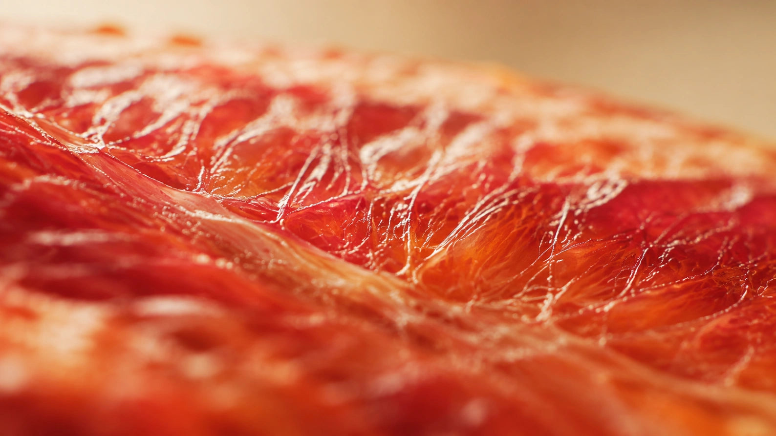 Extreme close-up abstract photograph of citrus membrane texture with warm lighting, representing CoQ10